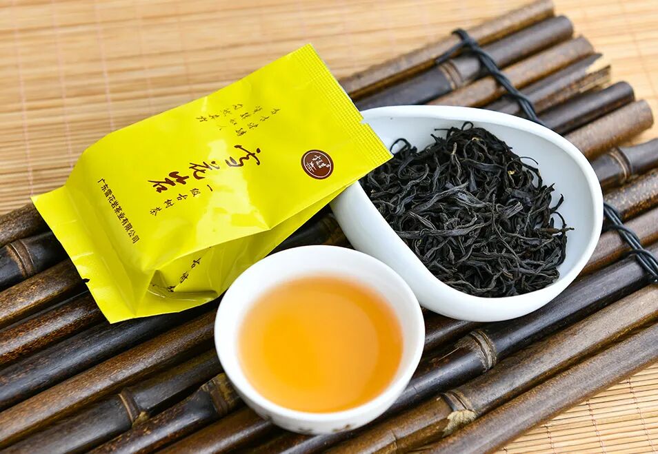 Snow Flower Rock wild ancient tree black tea — dry leaves, amber liquor, and gold packaging